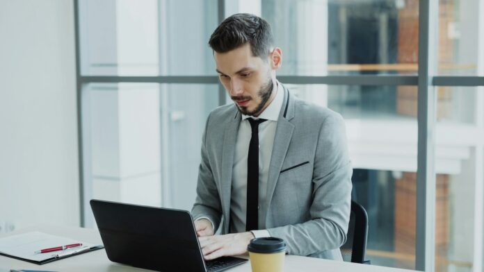 agente de seguros sentado na mesa no laptop