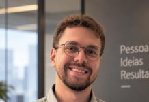 Akad anuncia Anderson Souza como novo gerente de canais de pequenos e médios corretores e assessorias Anderson Souza, novo gerente de canais PMC da Akad Seguros, sorri em escritório corporativo